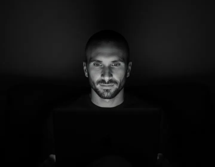 Kyle Rutten, who designs and builds every Bullfinch site, lit by his laptop screen