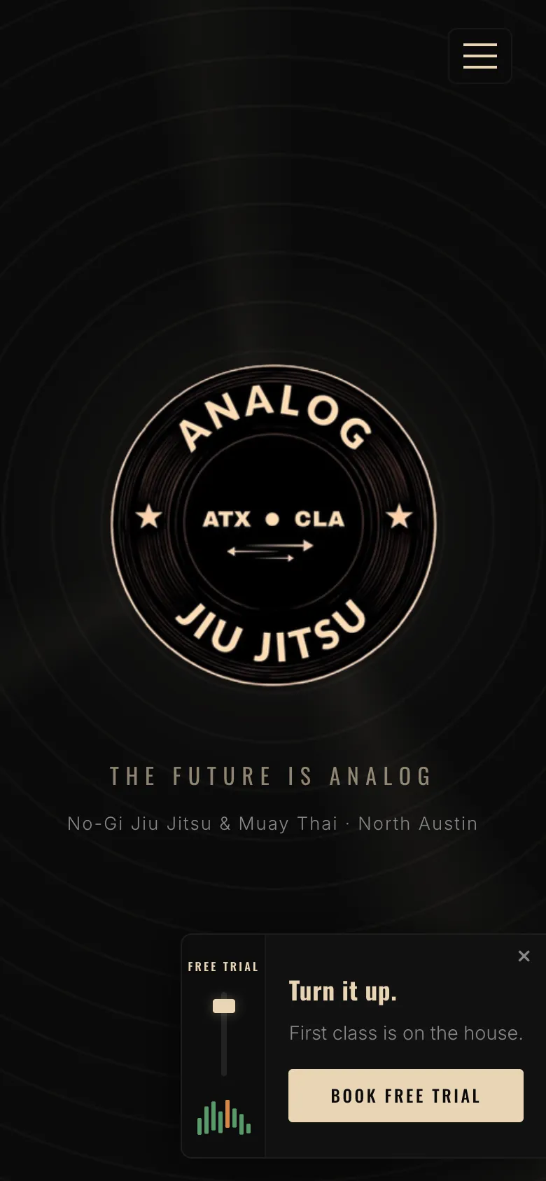 Analog Jiu Jitsu homepage on a phone: black page with the gym's round emblem and a trial class booking card