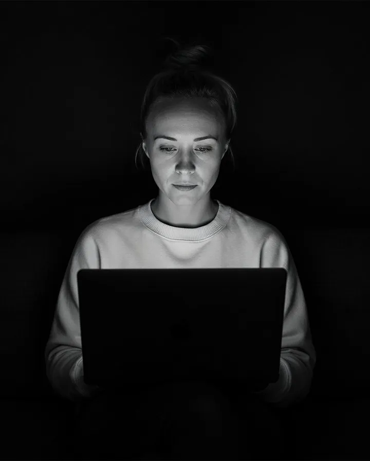 Katie Rutten, who runs Bullfinch's projects and schedules, working on a laptop in a dark room