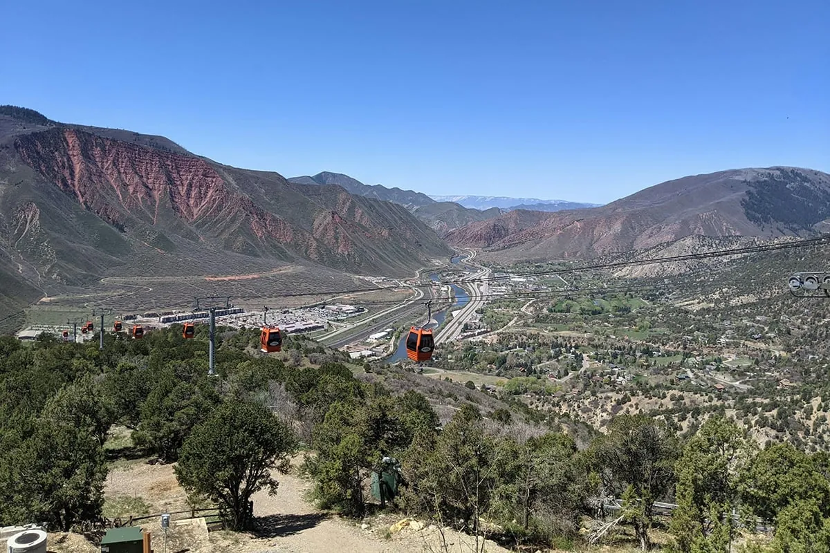 Orange Glenwood Caverns gondola cars above the town, with the river and I-70 running through the valley below