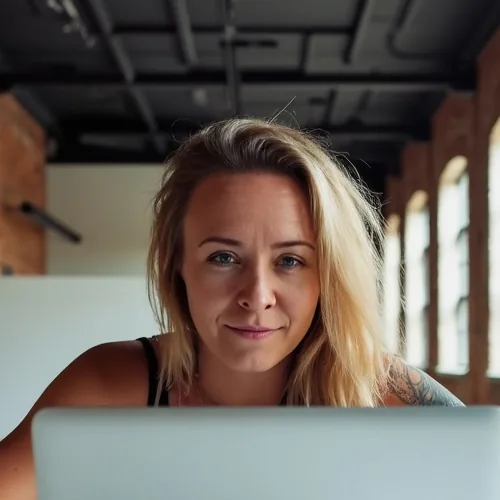 Katie, who runs Bullfinch projects and client accounts, at her laptop in a sunlit brick loft