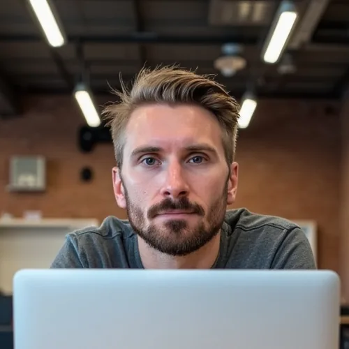 Kyle, who designs and builds Bullfinch websites, behind his laptop in a brick-walled workspace