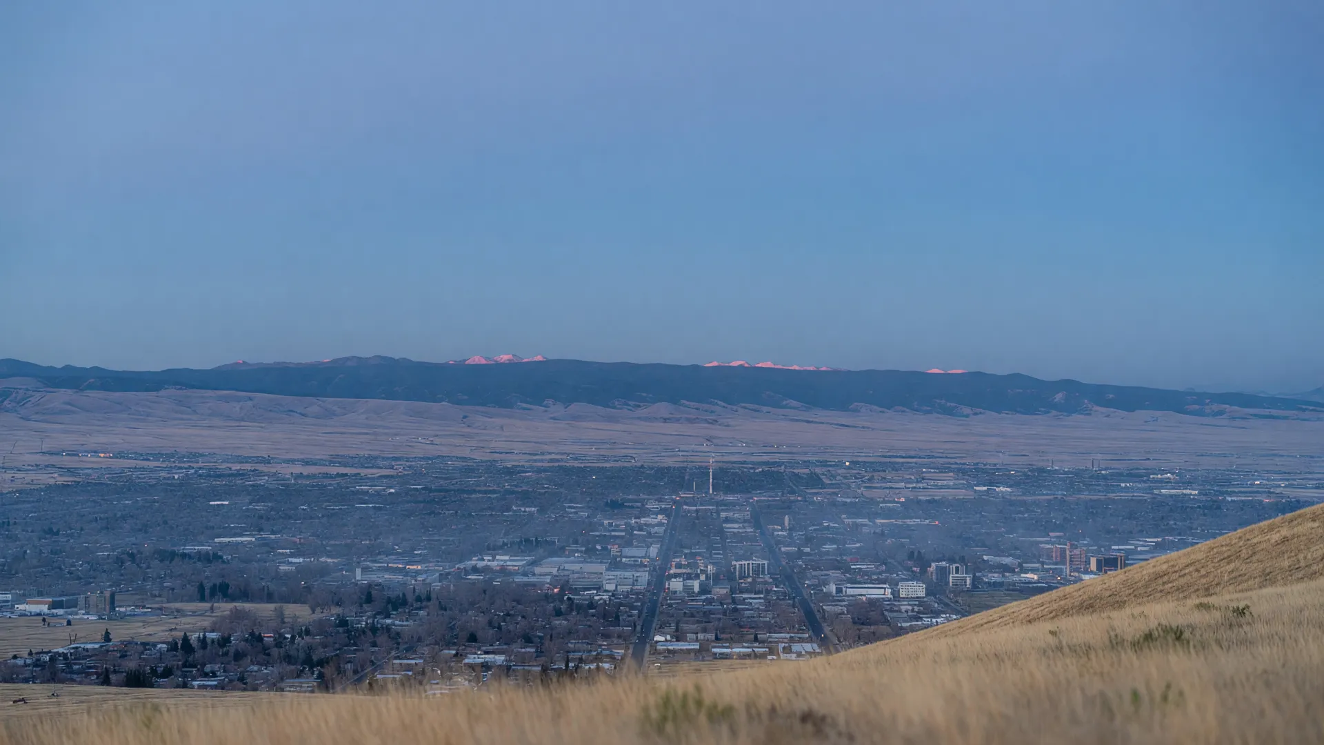 The Salt Lake Valley at first light from the east foothills, the city grid below and mountains across the valley