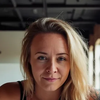 Katie Rutten, shoulder-length blonde hair, smiling slightly at the camera